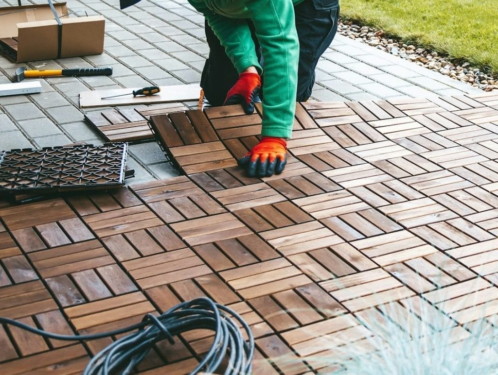 A man worker laying wooden flooring on the terrace